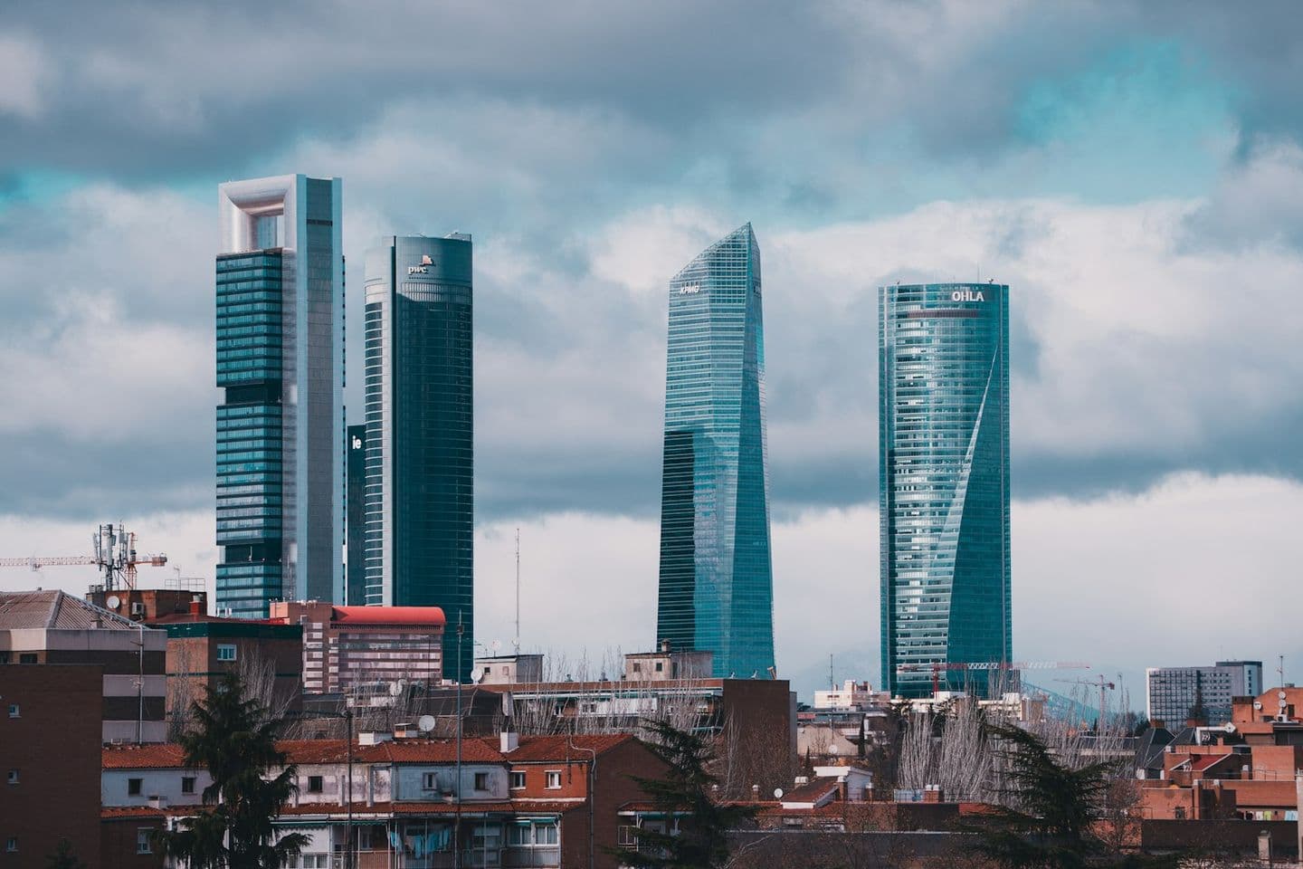 Los rascacielos de las Cuatro Torres de Madrid sobre los tejados de la ciudad en un día nublado.