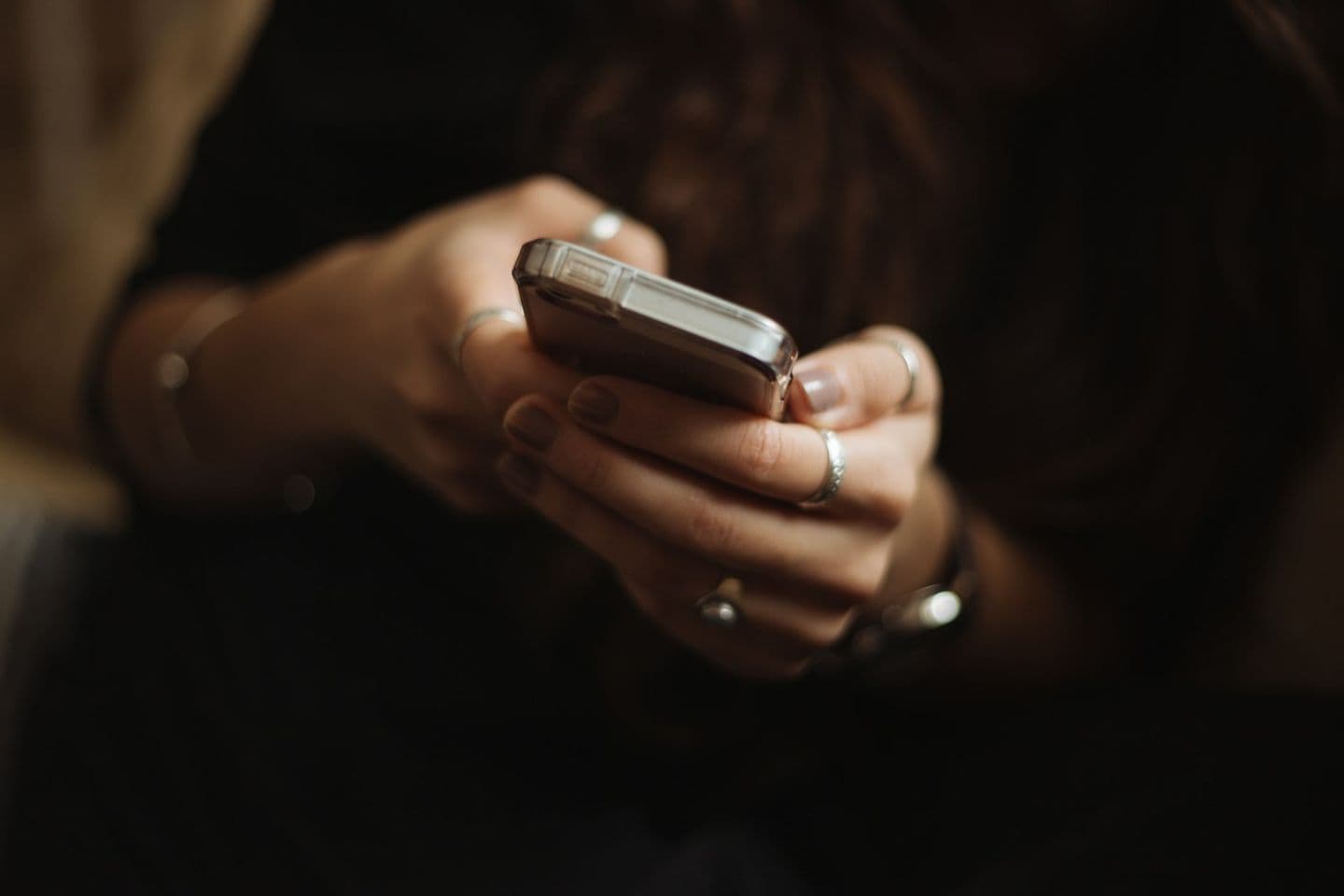 Primer plano de unas manos escribiendo un mensaje en un teléfono móvil.